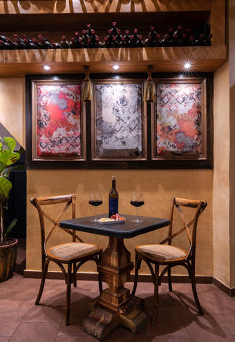 Decan Concept Boutique Estate Hotel Rhodes Bistro table with two chairs, two glasses of red wine and a wine bottle